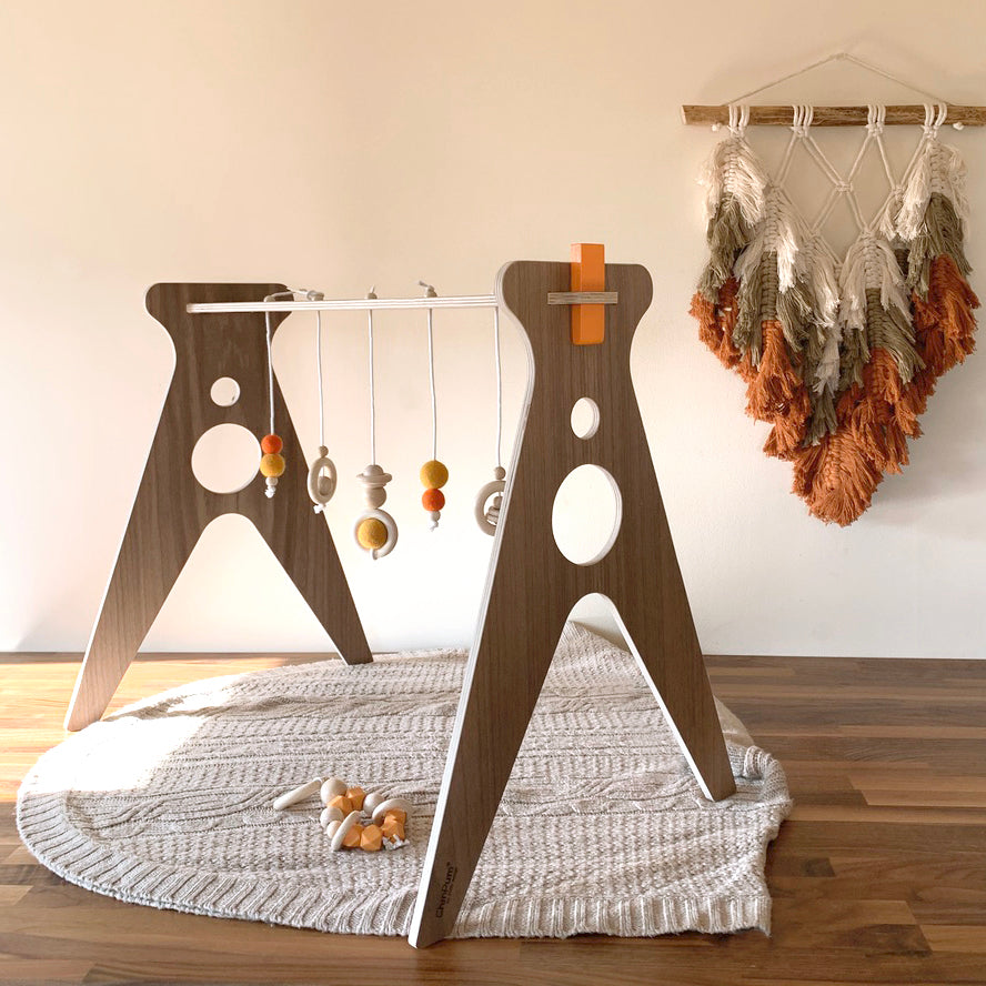 Gimnasio de madera para bebes de nogal y colgantes en color naranja Chin Pum
