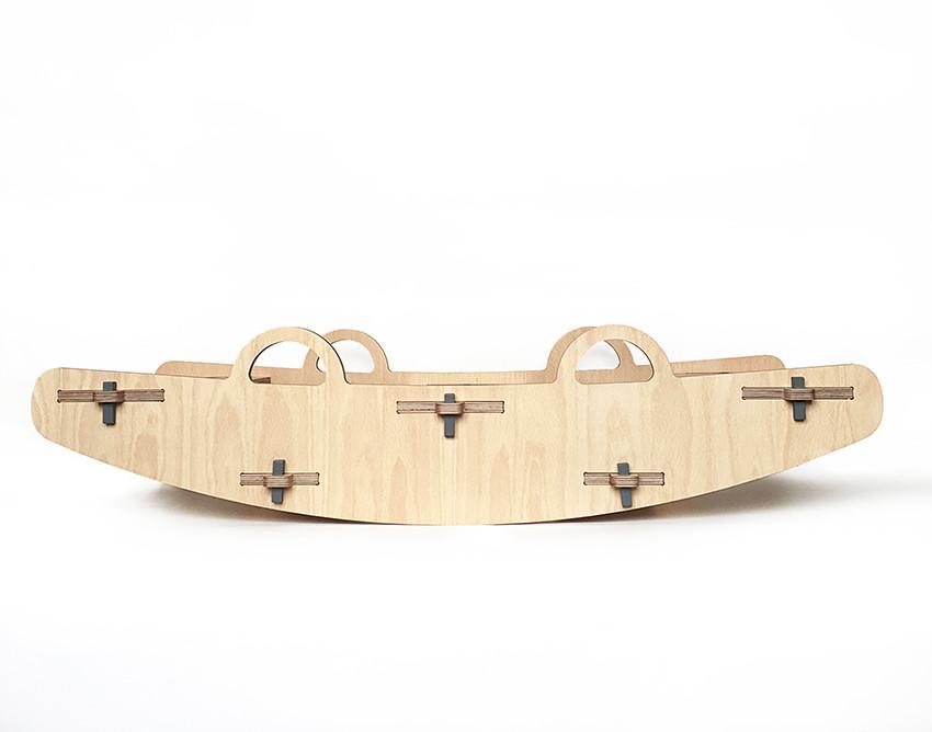Lateral de un balancín grande de madera para jugar varios niños a la vez.