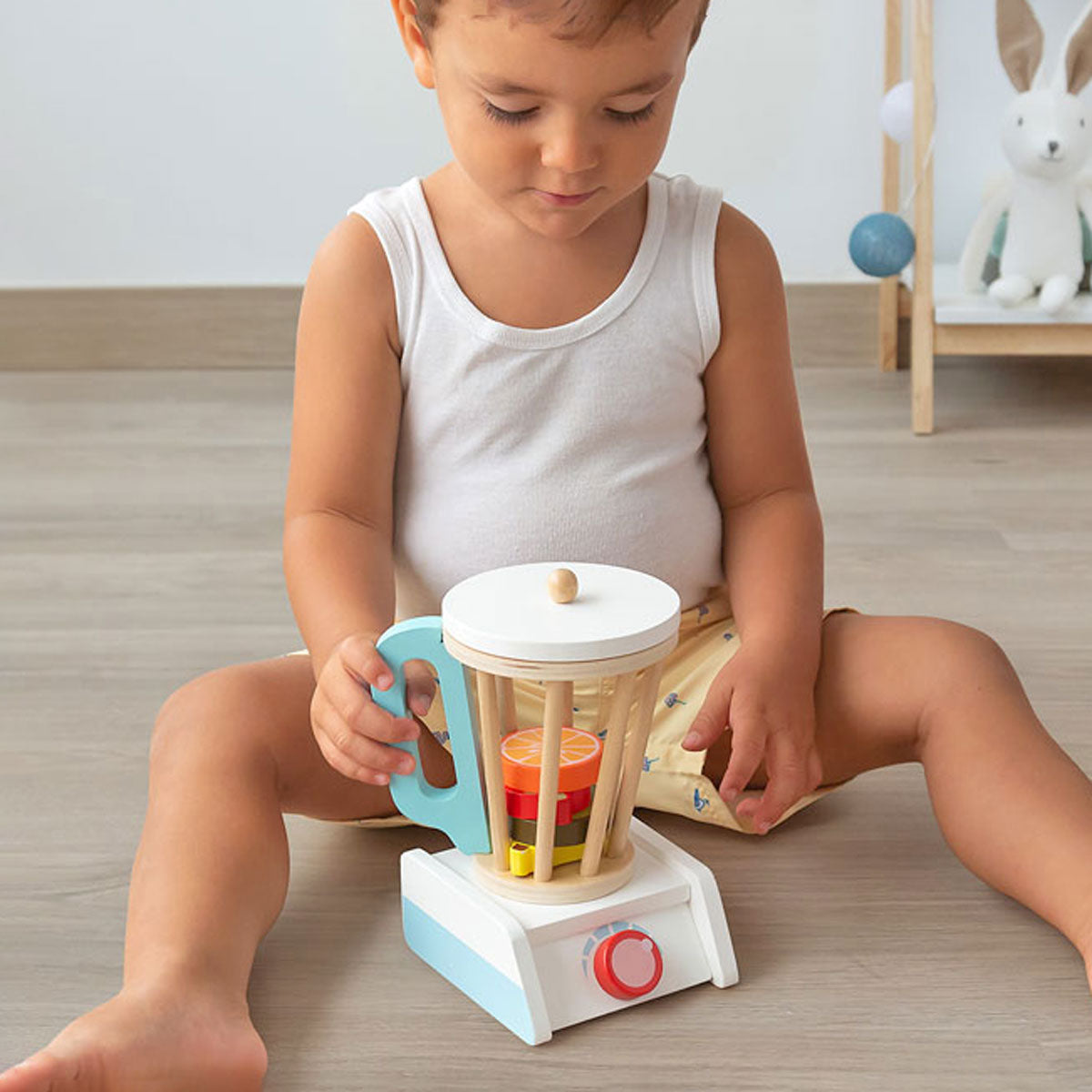 Niño jugando con una batidora de juguete