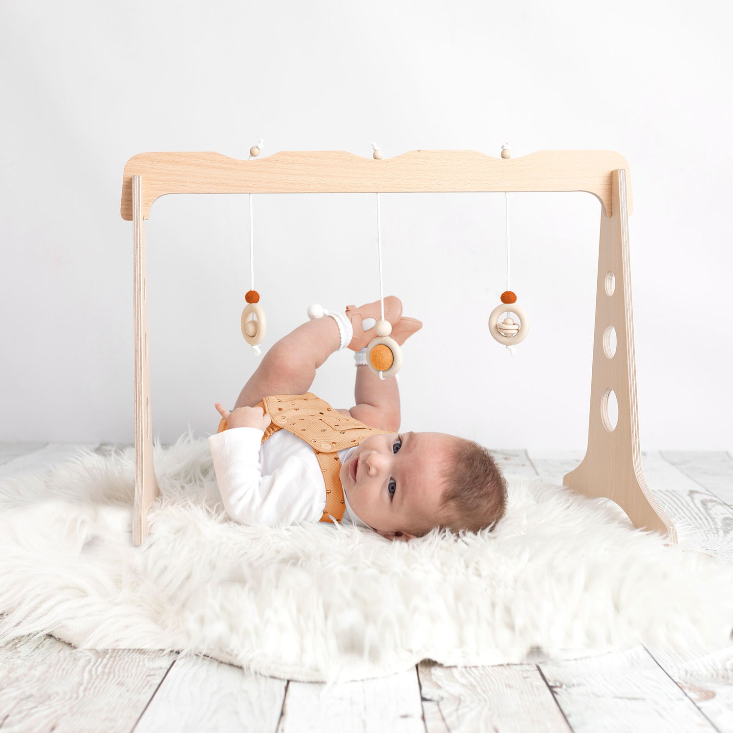 Bebé jugando con un gimnasio para bebés de madera de 3 colgantes de la marca ChinPum