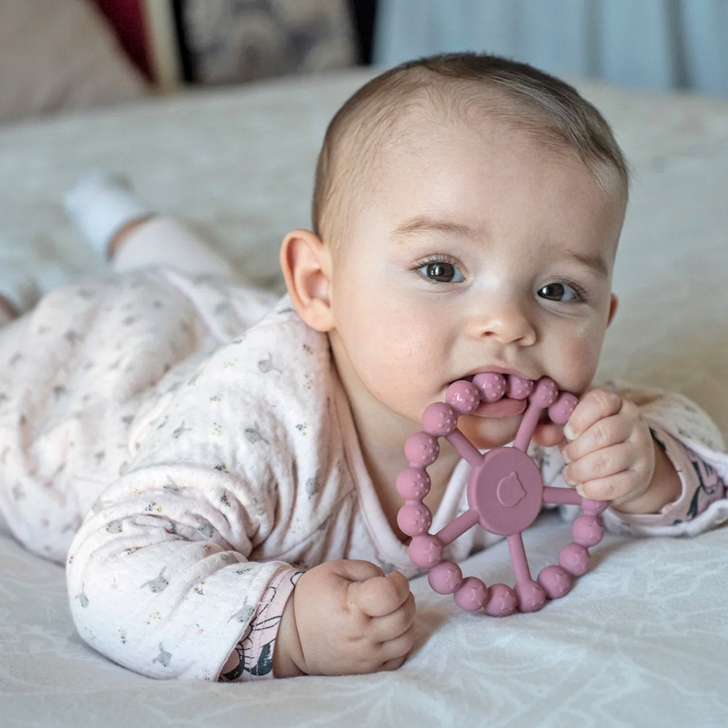 Bebé con mordedor de silicona  de rueda color morado 