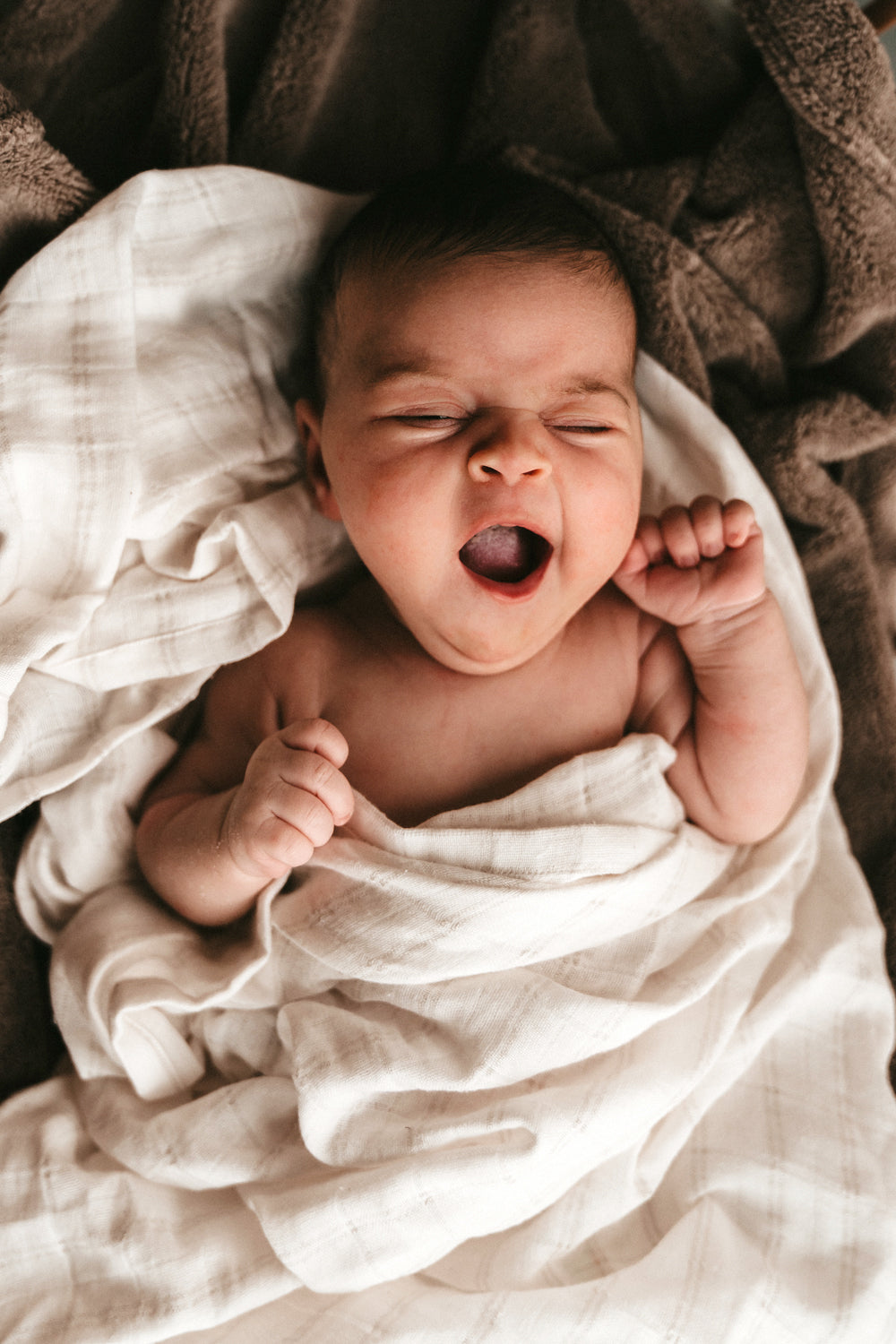 Bebé despertando con una muselina blanca