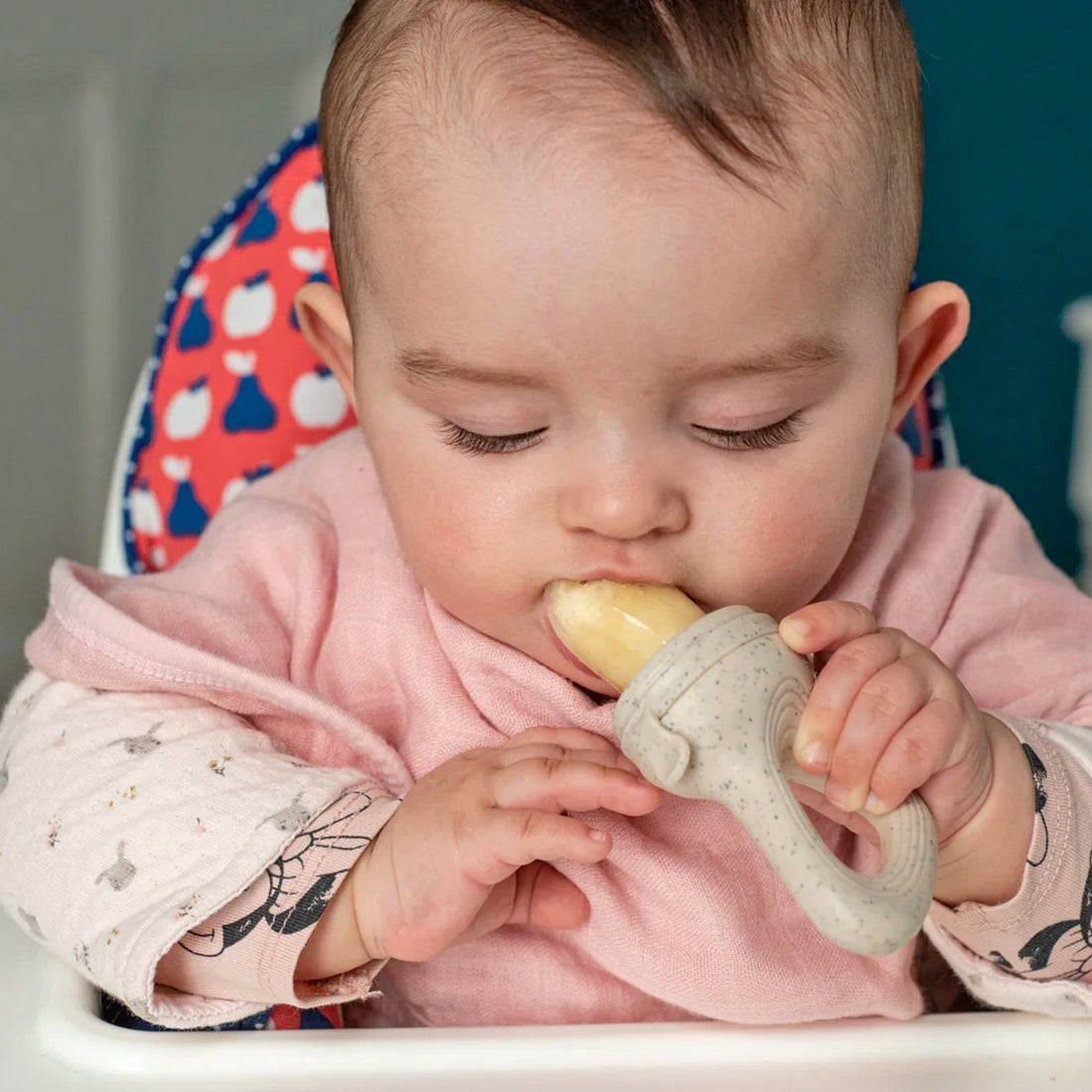 Bebé comiendo con un chupete alimentador