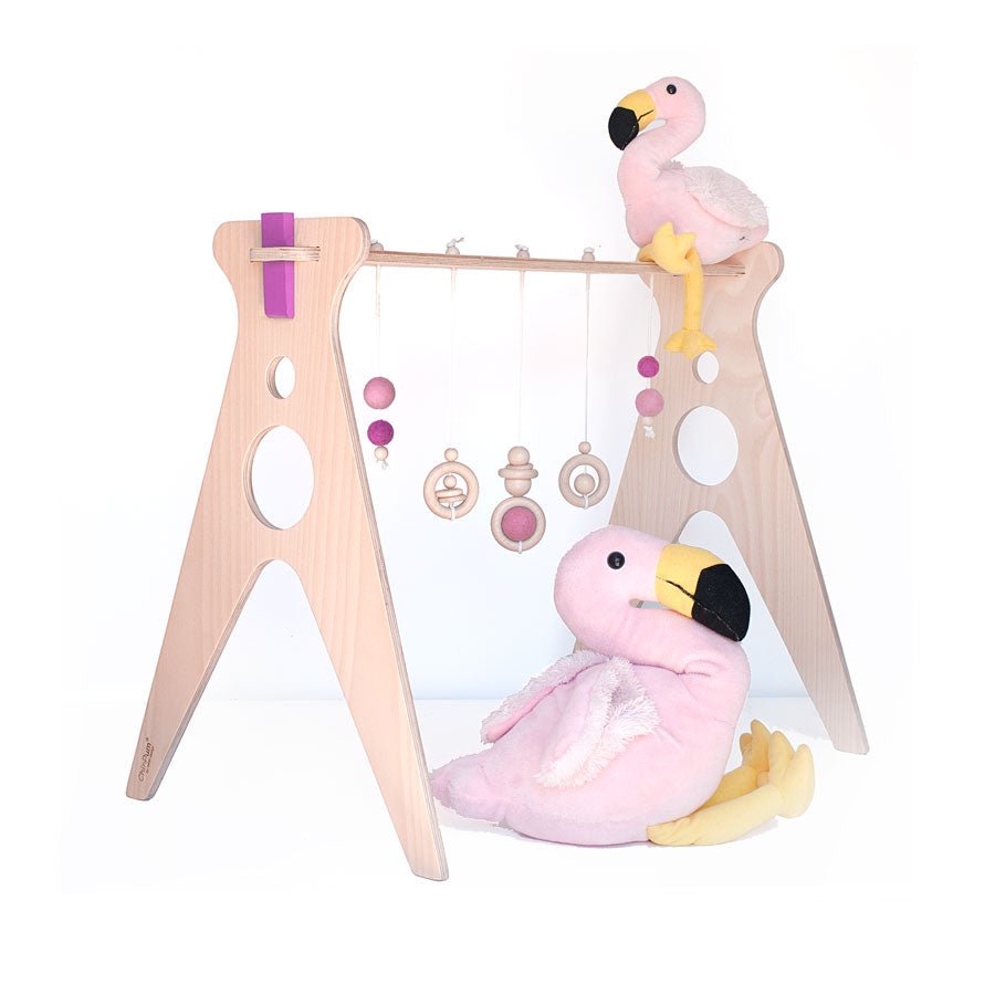 gimnasio para bebé de madera con complementos en color rosa